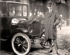 Henry Ford framför en av sina bilar.